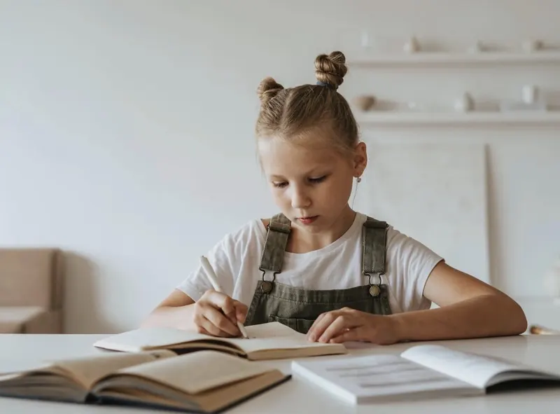 A child doing math on paper at a desk