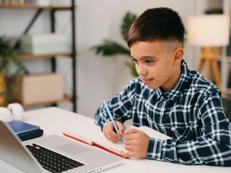 A child doing math on paper at a desk