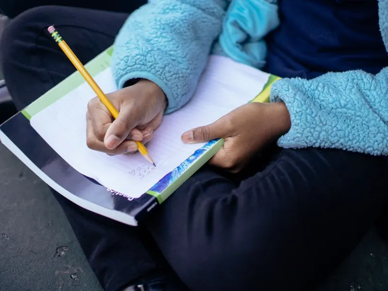 A child doing math on paper at a desk