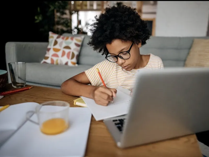 Un enfant qui fait des maths sur papier à un bureau