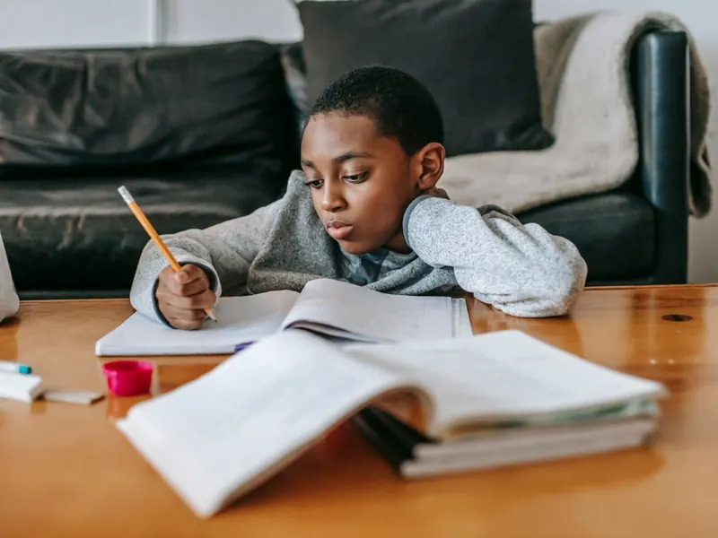 Un niño haciendo matemáticas en papel en un escritorio