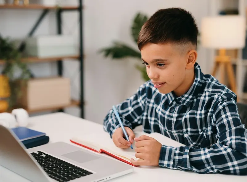 A child doing math on paper at a desk