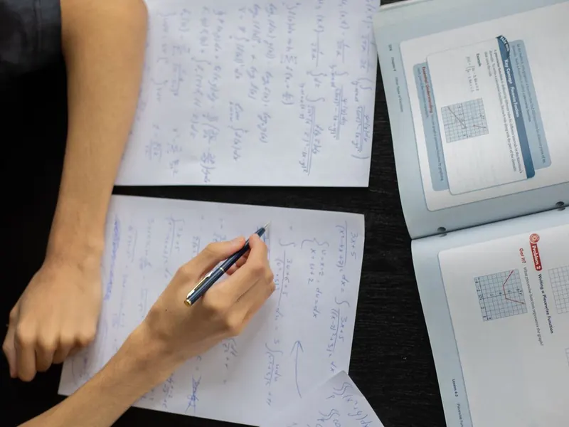 Uma criança fazendo matemática no papel em uma mesa